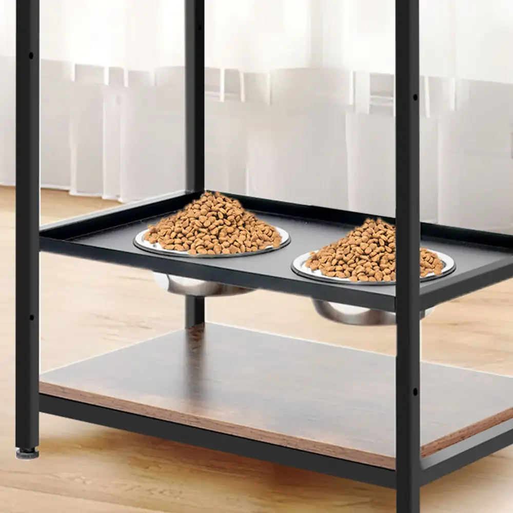 Two stainless steel raised dog bowls filled with dry food on the lower shelf of the feeding station
